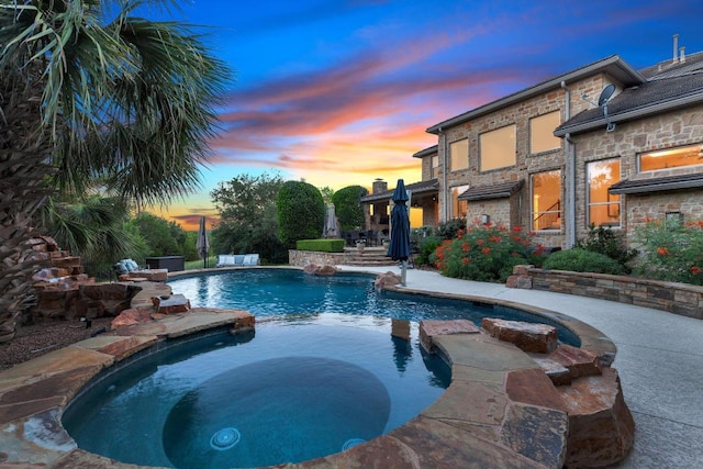 14417 Heron Bay Cv, Bee Cave, TX 78738 - pool at dusk with a pool with connected hot tub and a patio area