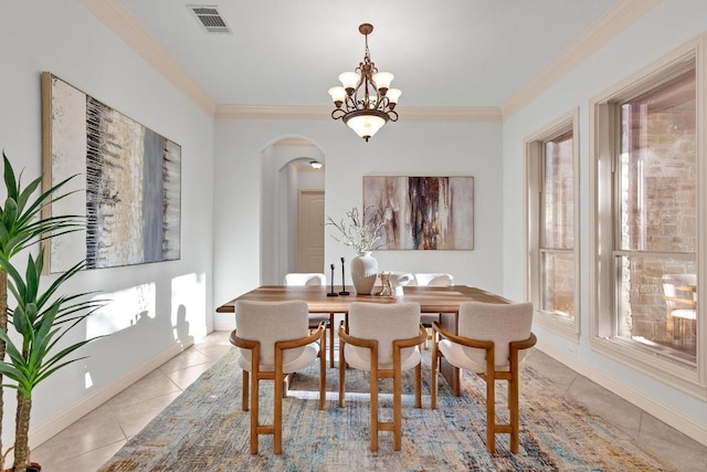14417 Heron Bay Cv, Bee Cave, TX 78738 - dining area featuring light tile patterned flooring, arched walkways, ornamental molding, and a chandelier