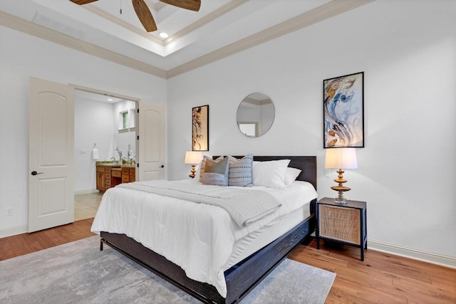 14417 Heron Bay Cv, Bee Cave, TX 78738 - bedroom with ornamental molding, light wood-style floors, ensuite bath, a ceiling fan, and a tray ceiling