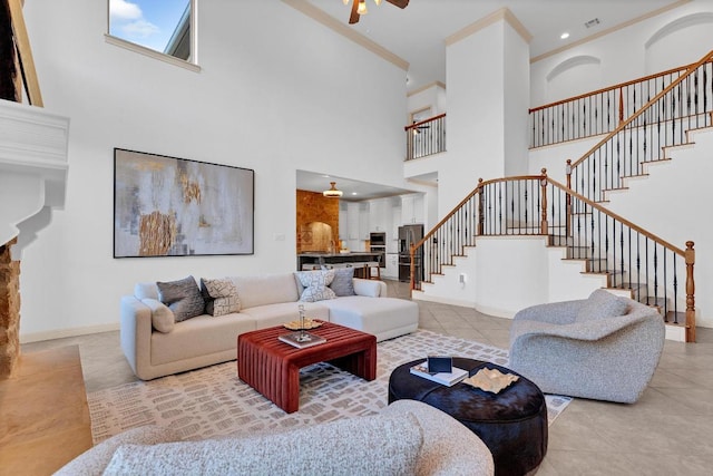 14417 Heron Bay Cv, Bee Cave, TX 78738 - living room featuring stairs, a towering ceiling, light tile patterned flooring, a ceiling fan, and ornamental molding