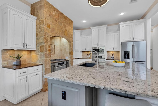 14417 Heron Bay Cv, Bee Cave, TX 78738 - kitchen with appliances with stainless steel finishes, light stone counters, white cabinets, decorative backsplash, and recessed lighting