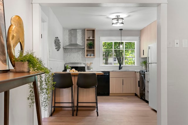 1040 Rosemont St, Austin, TX 78723 - kitchen with wall chimney exhaust hood, black dishwasher, range, light wood finished floors, and light brown cabinets