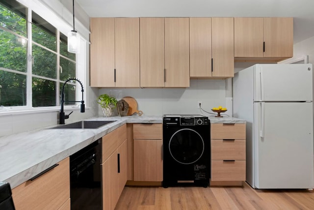 1040 Rosemont St, Austin, TX 78723 - kitchen with freestanding refrigerator, black dishwasher, light brown cabinetry, washer / clothes dryer, and light wood finished floors