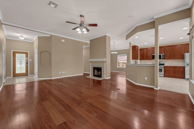 202 Muscovy Ln, Cedar Park, TX 78613 - unfurnished living room with a ceiling fan, wood finished floors, a fireplace with flush hearth, and ornamental molding