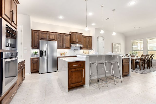 2707 Saint Paul Rivera Ln, Round Rock, TX 78665 - kitchen with appliances with stainless steel finishes, under cabinet range hood, light countertops, light tile patterned floors, and recessed lighting