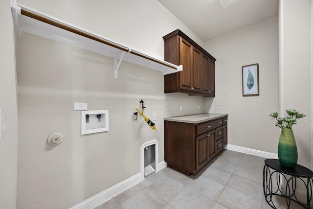 14016 Tyburn Trl, Austin, TX 78717 - washroom with washer hookup, gas dryer hookup, light tile patterned flooring, and cabinet space