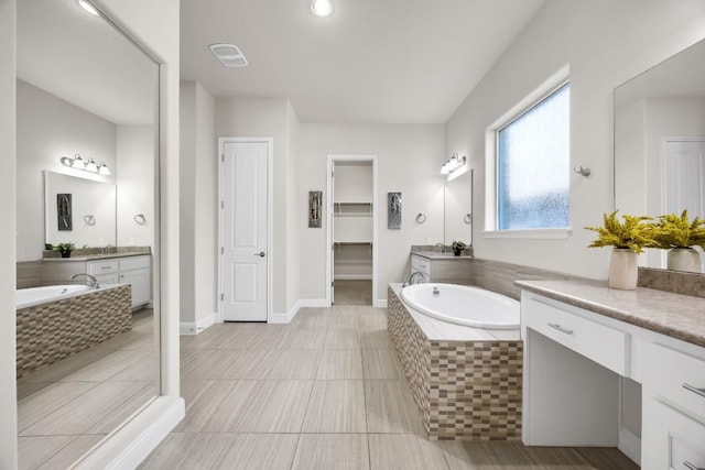 14016 Tyburn Trl, Austin, TX 78717 - bathroom featuring two vanities, a bath, tile patterned flooring, and a spacious closet