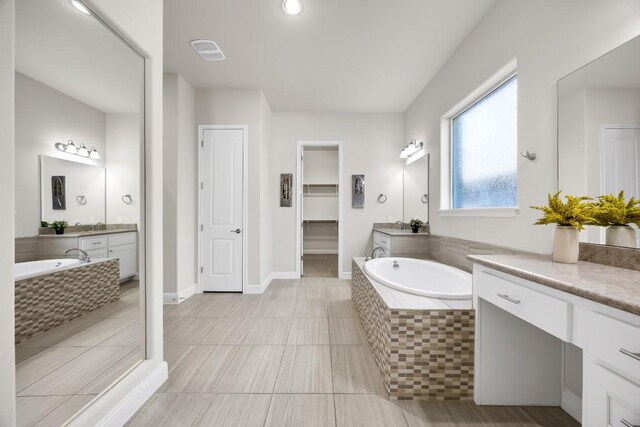 14016 Tyburn Trl, Austin, TX 78717 - full bath with two vanities, a garden tub, tile patterned floors, and a spacious closet