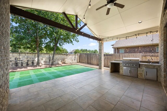 14016 Tyburn Trl, Austin, TX 78717 - fenced backyard featuring exterior kitchen, a ceiling fan, and a patio area