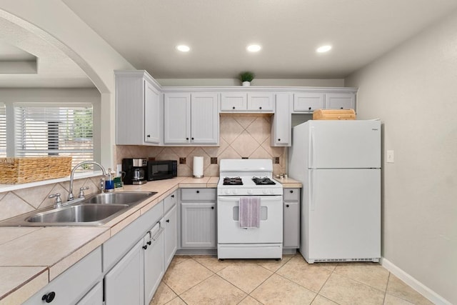 7215 Bennett Ave, Austin, TX 78752 - kitchen with white appliances, backsplash, arched walkways, recessed lighting, and light tile patterned floors