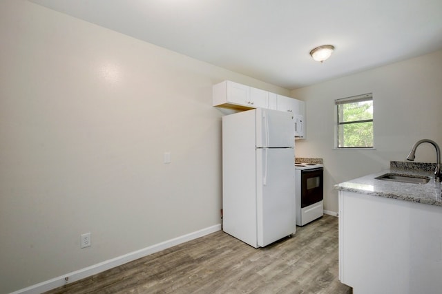 4307 S 1st St Unit 103, Austin, TX 78745 - kitchen with white appliances, light wood-type flooring, white cabinets, and light stone counters
