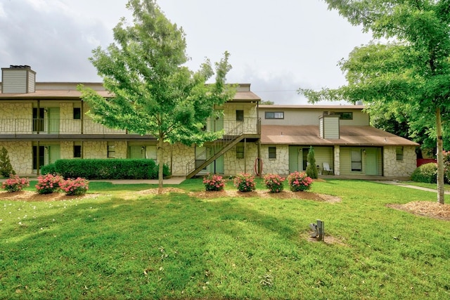4307 S 1st St Unit 103, Austin, TX 78745 - view of front of house with stone siding, stairs, and a front yard