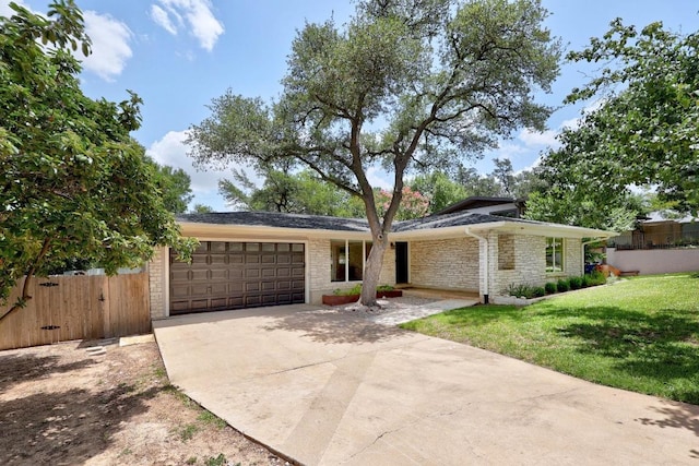 3518 Lakeland Dr, Austin, TX 78731 - view of front of house featuring an attached garage, concrete driveway, and stone siding
