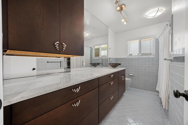 3518 Lakeland Dr, Austin, TX 78731 - bathroom featuring double vanity, tile patterned flooring, tile walls, and curtained shower