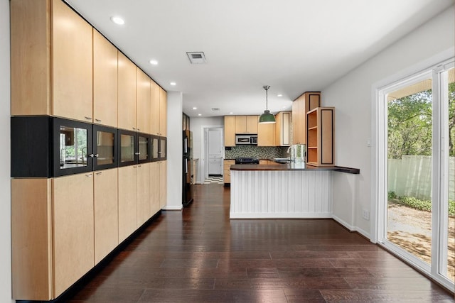3518 Lakeland Dr, Austin, TX 78731 - kitchen with black appliances, a peninsula, dark countertops, decorative backsplash, and dark wood-style floors