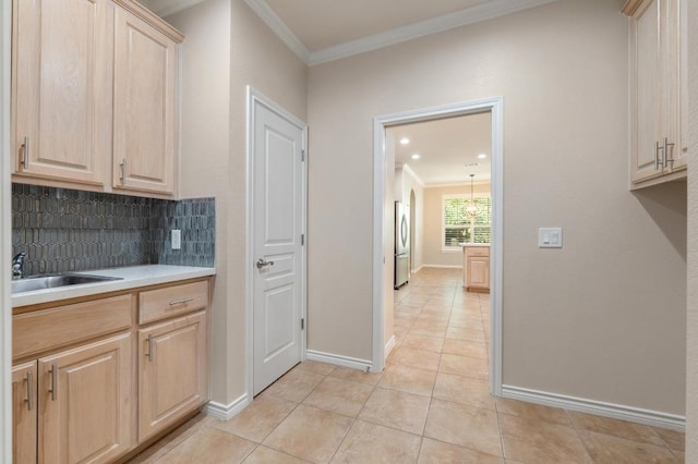 811 River Walk Trl, Georgetown, TX 78633 - kitchen with light brown cabinets, crown molding, light countertops, light tile patterned floors, and decorative backsplash