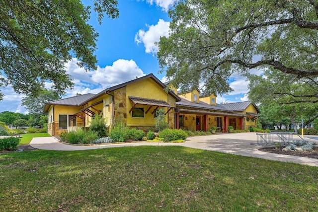 811 River Walk Trl, Georgetown, TX 78633 - view of front of home featuring stone siding, a front lawn, a metal roof, and a standing seam roof