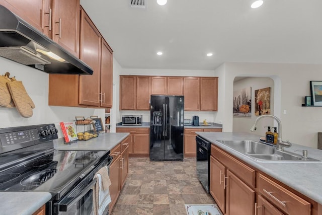 136 Everglades Ave, Taylor, TX 76574 - kitchen with black appliances, under cabinet range hood, recessed lighting, stone finish flooring, and light countertops