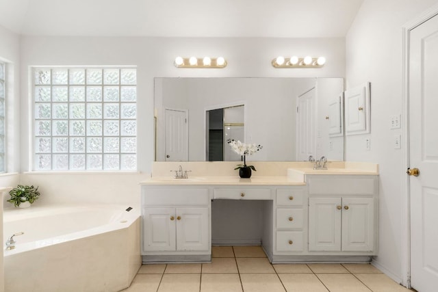 4917 Flaming Oak Cv, Austin, TX 78749 - bathroom featuring double vanity, a garden tub, and tile patterned flooring