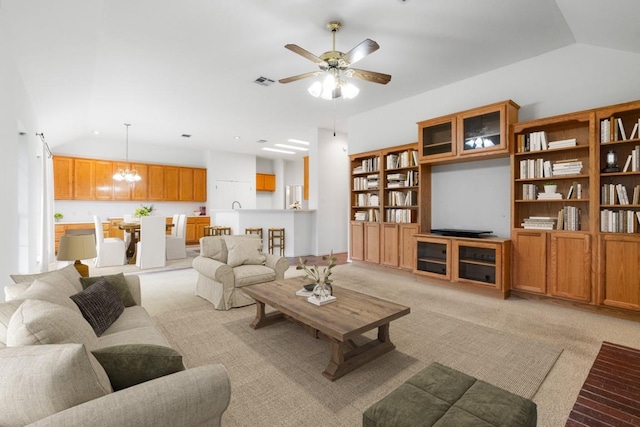 4917 Flaming Oak Cv, Austin, TX 78749 - living room with light colored carpet, a ceiling fan, vaulted ceiling, and a chandelier