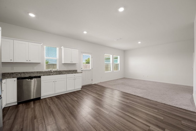 701 Redfish Ln, Hutto, TX 78634 - kitchen featuring stainless steel dishwasher, open floor plan, white cabinetry, dark wood finished floors, and dark stone counters