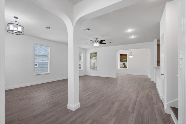 1102 Peyton Pl, Cedar Park, TX 78613 - unfurnished living room featuring arched walkways, dark wood-style floors, ceiling fan, a chandelier, and recessed lighting