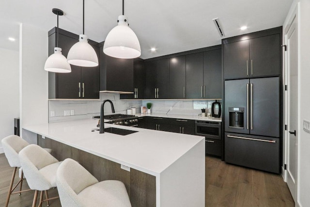 5700 Louise Ln, Austin, TX 78757 - kitchen featuring high end fridge, dark cabinets, dark wood-style floors, a breakfast bar area, and recessed lighting