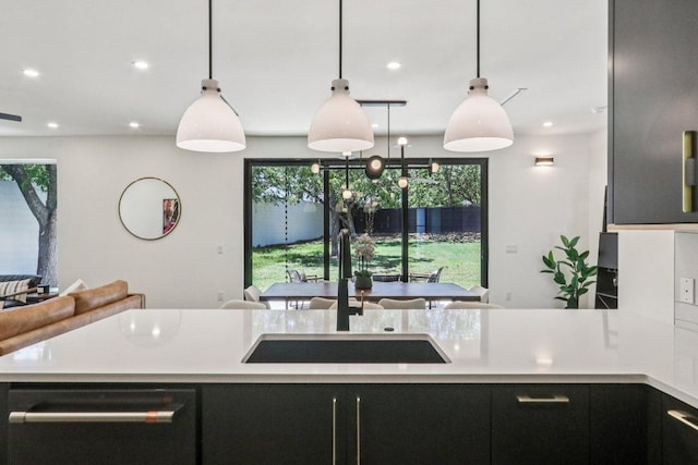 5700 Louise Ln, Austin, TX 78757 - kitchen featuring dishwashing machine, light countertops, plenty of natural light, recessed lighting, and dark cabinets