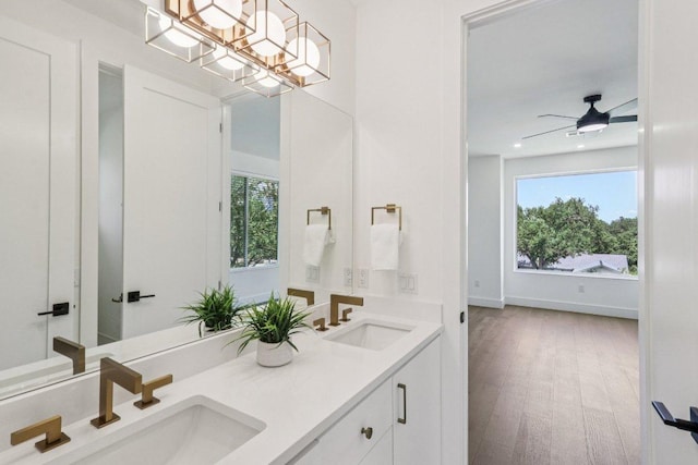 5700 Louise Ln, Austin, TX 78757 - bathroom with healthy amount of natural light, double vanity, wood finished floors, a chandelier, and recessed lighting