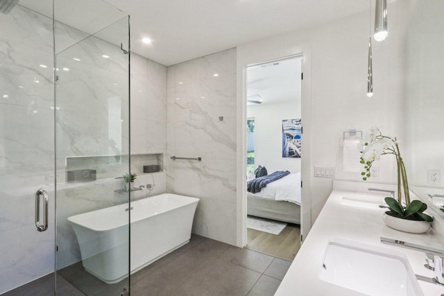 5700 Louise Ln, Austin, TX 78757 - ensuite bathroom with a freestanding bath, double vanity, tile patterned flooring, a stall shower, and tile walls