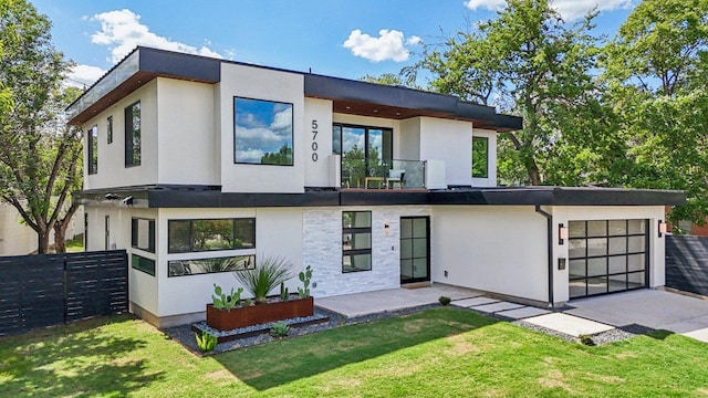 5700 Louise Ln, Austin, TX 78757 - view of front of house featuring stucco siding, driveway, a garage, and a balcony