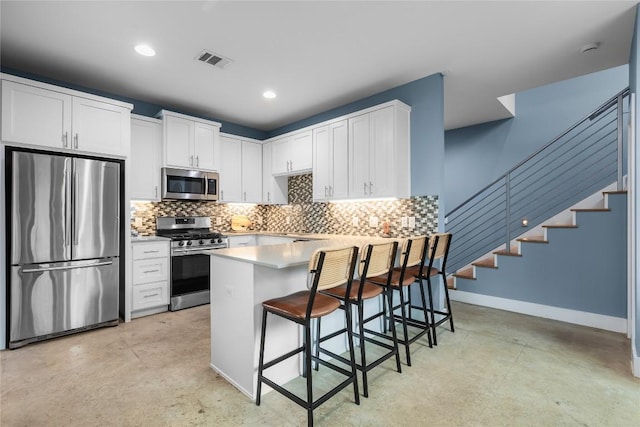 7606 Providence Ave Unit B, Austin, TX 78752 - kitchen with stainless steel appliances, concrete flooring, a peninsula, a kitchen bar, and recessed lighting