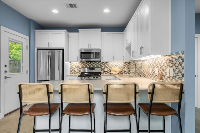 7606 Providence Ave Unit B, Austin, TX 78752 - kitchen featuring stainless steel appliances, light countertops, white cabinetry, decorative backsplash, and recessed lighting