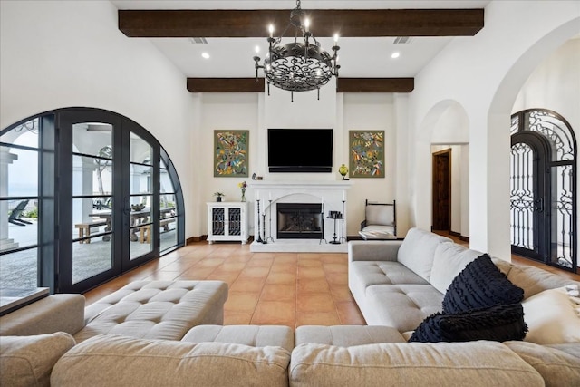 living room with beamed ceiling, healthy amount of natural light, a chandelier, arched walkways, and tile patterned floors
