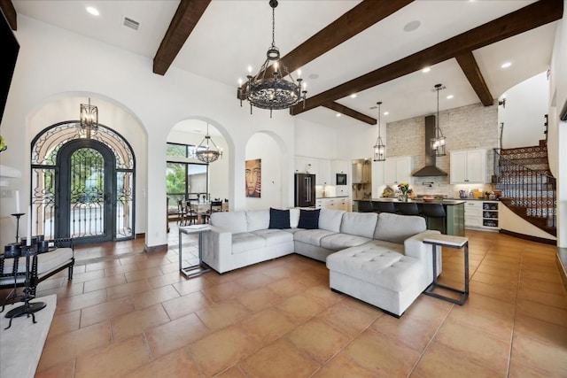 living room featuring a chandelier, beam ceiling, arched walkways, a high ceiling, and recessed lighting