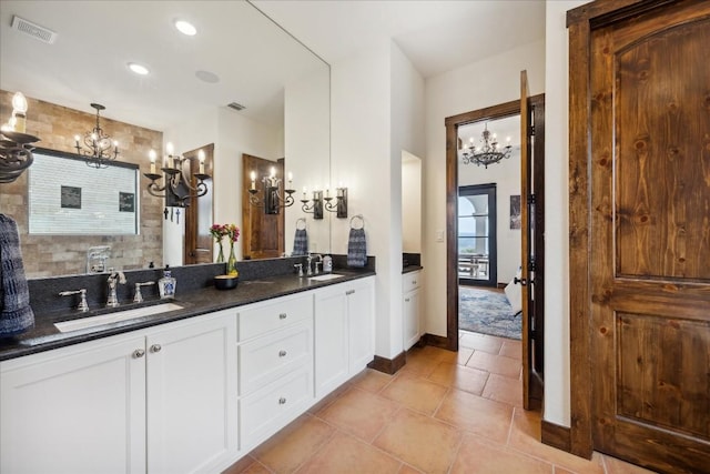 bathroom featuring a chandelier, double vanity, and tile patterned flooring