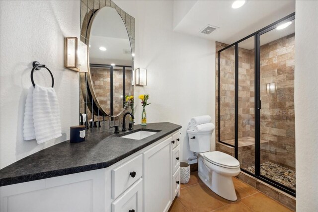 bathroom with vanity, a shower stall, tile patterned flooring, and recessed lighting