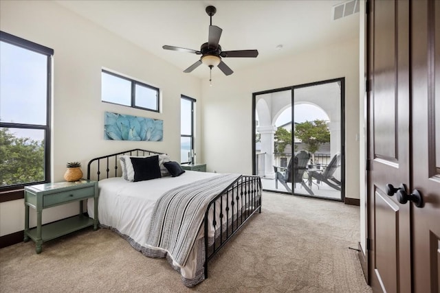 bedroom featuring light colored carpet, access to outside, and multiple windows