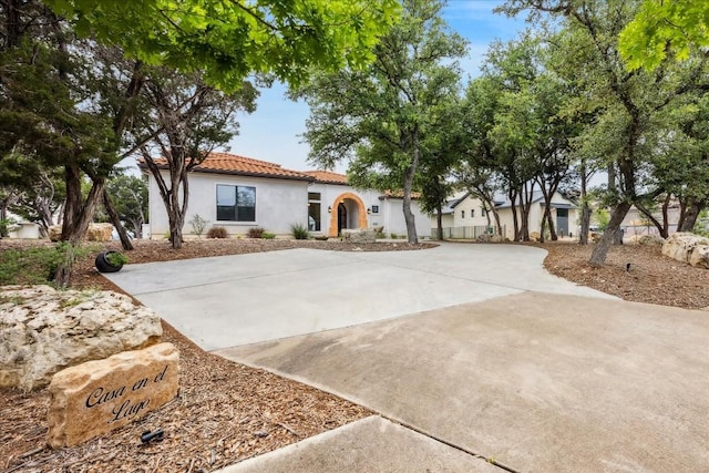 mediterranean / spanish-style house with stucco siding and a tiled roof