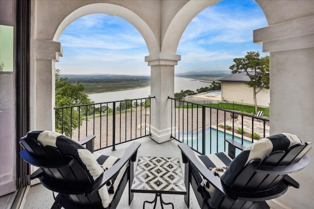 balcony featuring a water view and view of pool