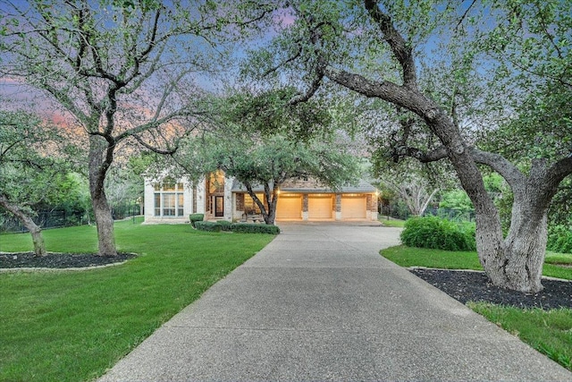 17120 Northlake Hills Dr, Jonestown, TX 78645 - view of front facade with concrete driveway, a front yard, a garage, and brick siding
