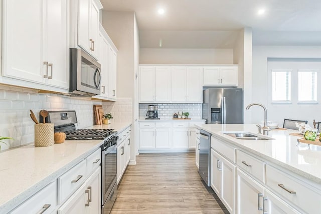 7901 Sunrise Ravine Pass, Lago Vista, TX 78645 - kitchen with appliances with stainless steel finishes, white cabinetry, decorative backsplash, light wood finished floors, and recessed lighting