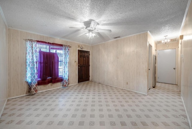 4705 Enchanted Ln, Austin, TX 78745 - foyer featuring crown molding, wooden walls, light flooring, a ceiling fan, and a chandelier