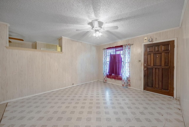 4705 Enchanted Ln, Austin, TX 78745 - empty room featuring a ceiling fan, tile patterned floors, wooden walls, crown molding, and a textured ceiling