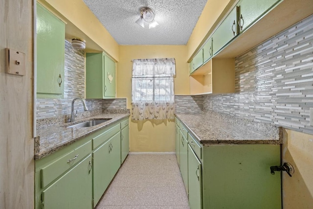 4705 Enchanted Ln, Austin, TX 78745 - kitchen featuring green cabinets, tasteful backsplash, a textured ceiling, and light stone counters