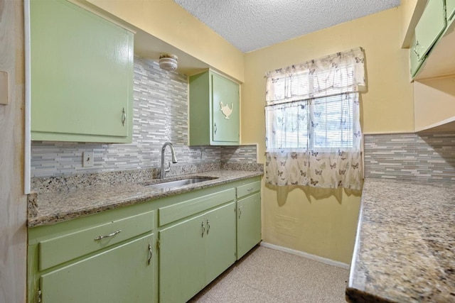 4705 Enchanted Ln, Austin, TX 78745 - kitchen featuring green cabinets, decorative backsplash, and a textured ceiling