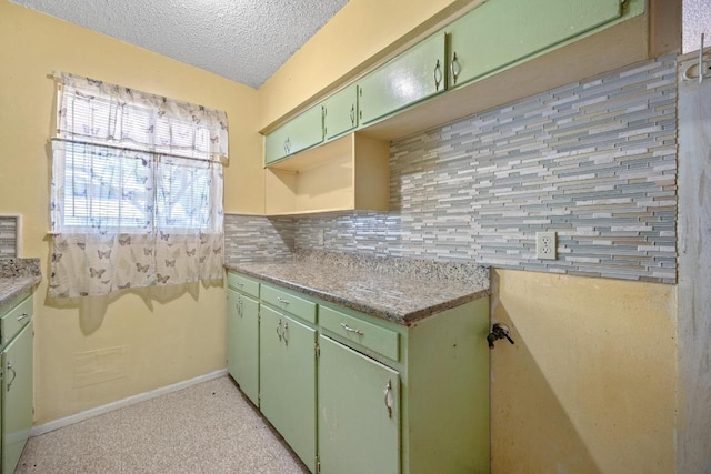 4705 Enchanted Ln, Austin, TX 78745 - kitchen featuring green cabinetry, a textured ceiling, backsplash, and light countertops