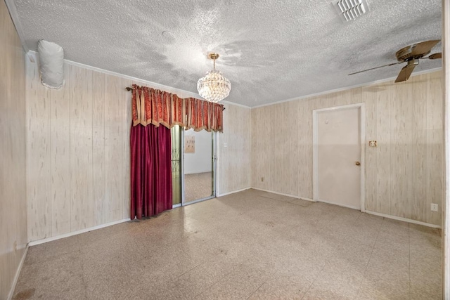 4705 Enchanted Ln, Austin, TX 78745 - unfurnished room featuring wood walls, ceiling fan, a textured ceiling, crown molding, and a chandelier