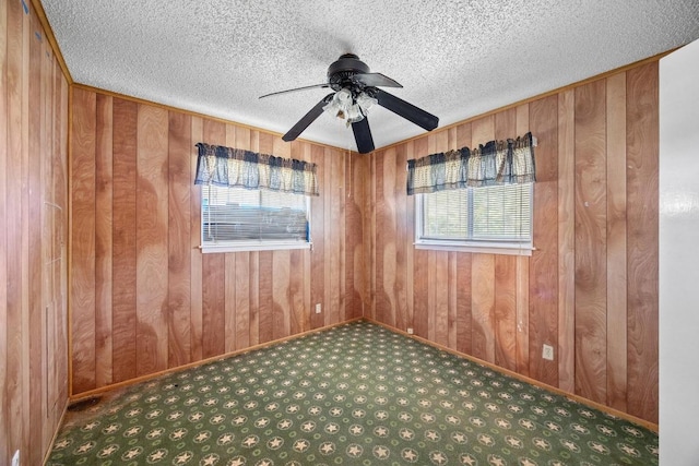 4705 Enchanted Ln, Austin, TX 78745 - spare room with carpet, a ceiling fan, wooden walls, and a textured ceiling