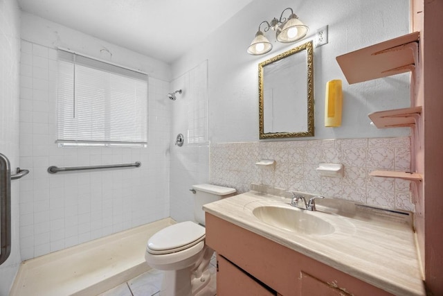 4705 Enchanted Ln, Austin, TX 78745 - full bathroom featuring a tile shower, vanity, tile walls, wainscoting, and tile patterned flooring